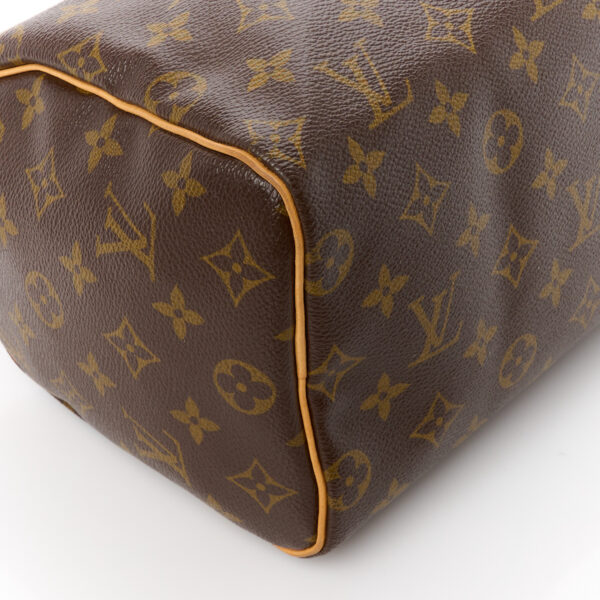 This is an authentic LOUIS VUITTON Monogram Speedy 25. This stylish small tote is crafted of signature Louis Vuitton monogram on toile canvas. This handbag features vachetta cowhide leather top handles and trim with polished brass hardware. The top zipper opens to a cocoa brown fabric interior with a hanging pocket.